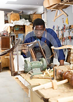 Professional restorer renewing vintage armchair