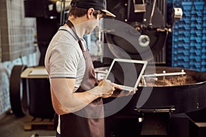 Professional roaster using modern laptop at work