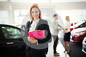 Professional saleswoman working in car dealership