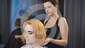 In the professional salon hairstyle on the girl's head dried hairdryer.