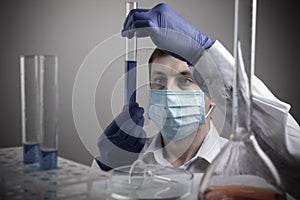 Professional scientist holding a test tube and tablet while making a research