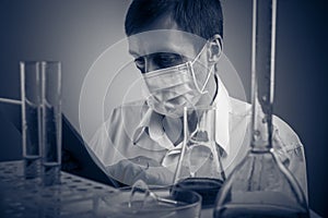 Professional scientist holding a test tube and tablet while making a research