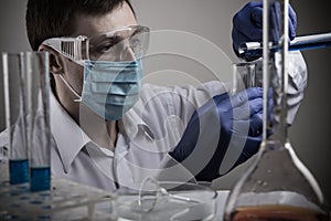 Professional scientist holding a test tube and tablet while making a research