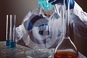 Professional scientist holding a test tube and tablet while making a research