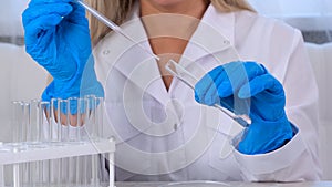 professional scientist takes a sample for a medical experiment. A research chemist works in a laboratory with a