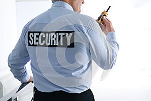 Professional security guard with portable radio set, closeup