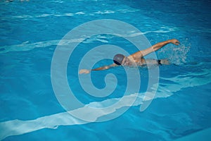 Professional senior man swimmer doing exercise in indoor swimming pool