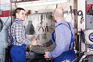 Professional servicemen in repair shop