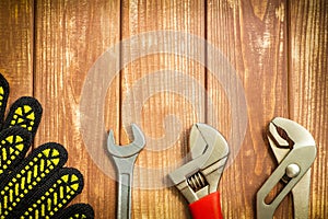 Professional set of tool and work gloves for plumbers on a vintage wooden boards