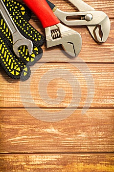 Professional set of tools and work gloves for plumbers on a vintage wooden boards