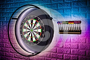 Professional sisal steeldart board with steel dart holder in colorful LED illumination white stone wall. leisure time hobby sport