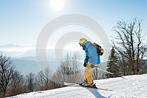 Professional skier enjoying skiing in mountains on sunny winter day on the winter resort