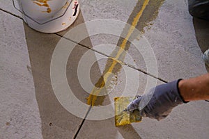 professional is skillfully filling the expansion joints with epoxy mortar using a trowel and putty knife, ensuring that the photo