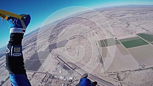 Professional skydiver fly on parachute in blue sky above sandy Arizona. Sun