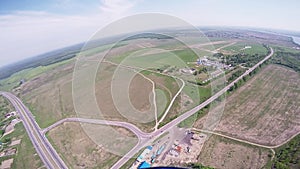 Professional skydiver fly in sky above green fields, road, cars. Sun. Landscape.