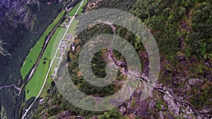 Professional skydiver parachuting above mountain covered by green trees. Scenery