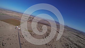 Professional skydiver parachuting above sandy country. Landscape. Landing. Sunny