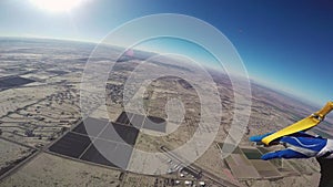 Professional skydiver parachuting in blue sky above Arizona. Sunny. Height.