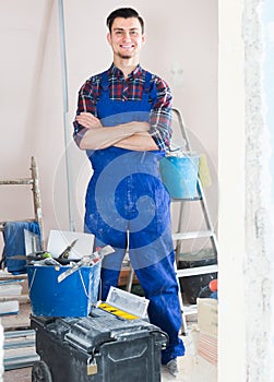 professional smiling builder standing in repairable room