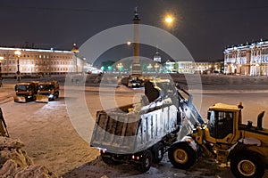 Professional snow removal equipment clearing Palace Square at night after intense snowfall in city