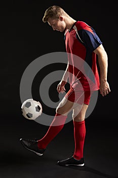 Professional Soccer Player Controlling Ball In Studio