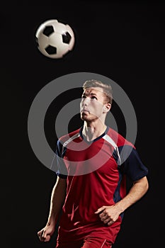 Professional Soccer Player Heading Ball In Studio