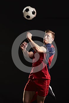 Professional Soccer Player Jumping To Head Ball In Studio