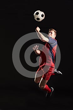 Professional Soccer Player Jumping To Head Ball In Studio