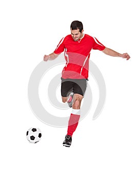 Professional soccer player kicking ball