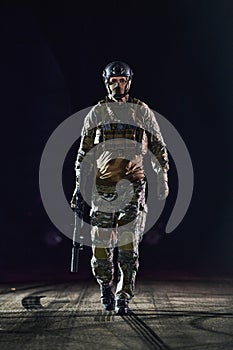 A professional soldier in full military gear striding through the dark night as he embarks on a perilous military