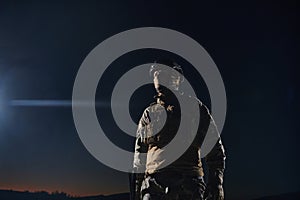 A professional soldier in full military gear striding through the dark night as he embarks on a perilous military