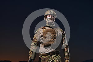 A professional soldier in full military gear striding through the dark night as he embarks on a perilous military