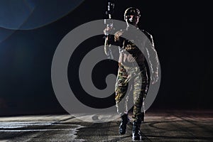 A professional soldier in full military gear striding through the dark night as he embarks on a perilous military