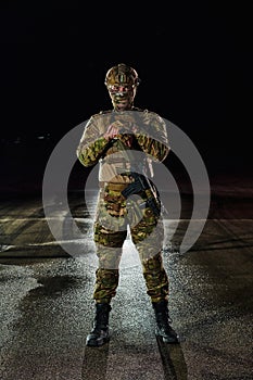 A professional soldier in full military gear striding through the dark night as he embarks on a perilous military