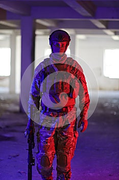 A professional soldier undertakes a perilous mission in an abandoned building illuminated by neon blue and purple lights