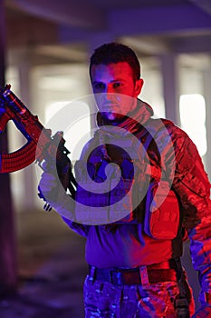 A professional soldier undertakes a perilous mission in an abandoned building illuminated by neon blue and purple lights