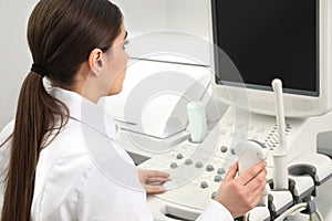 Professional sonographer using modern ultrasound machine photo