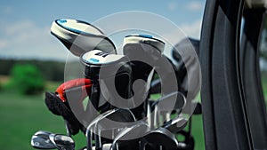 Professional sport golf clubs in bag outside. Putter equipment in golfing cart.