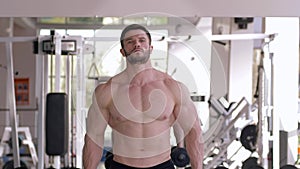 Professional sports, muscular guy doing strength exercise with dumbbells in hands during power training in gym