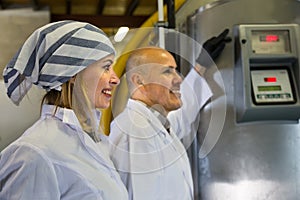 Professional staff posing near machine in modern fabrica photo