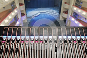 Professional stage lighting control console with blurred background of a stage