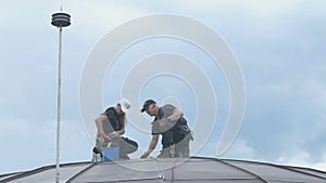 Professional steeplejacks are working at the roof of the business center