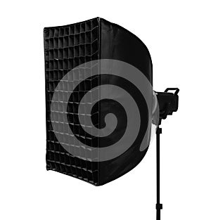 A professional studio softbox light with a honeycomb grid attachment on a stand isolated on a white