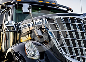 Professional stylish black big rig semi truck tractor with shiny chrome grille