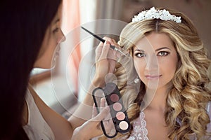 Professional Stylist makes makeup bride on the wedding day. Beau