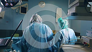 Professional Surgeon Standing in Surgical Mask Arms Crossed. In the Background Modern Hospital Operating Room with