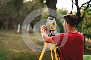 Professional surveyor engineer measuring and working with total station