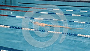 Professional swimmer in cap breathing performing the butterfly stroke