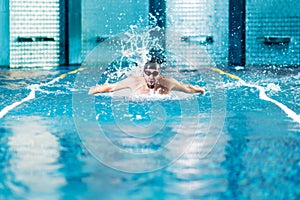 Professional swimmer doing exercise in indoor swimming pool