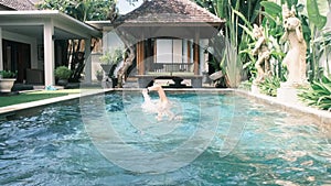 Professional swimmer in pool trains swimming freestyle in clear blue water, wearing swimming goggles. Professional